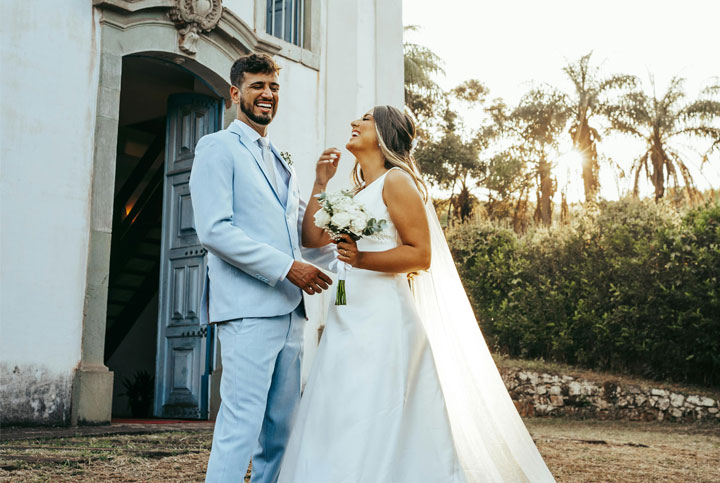 A couple on their wedding day outside happy and laughing